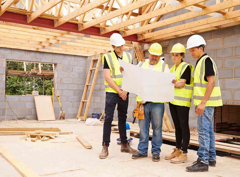 Builders reviewing plans inside a new build
